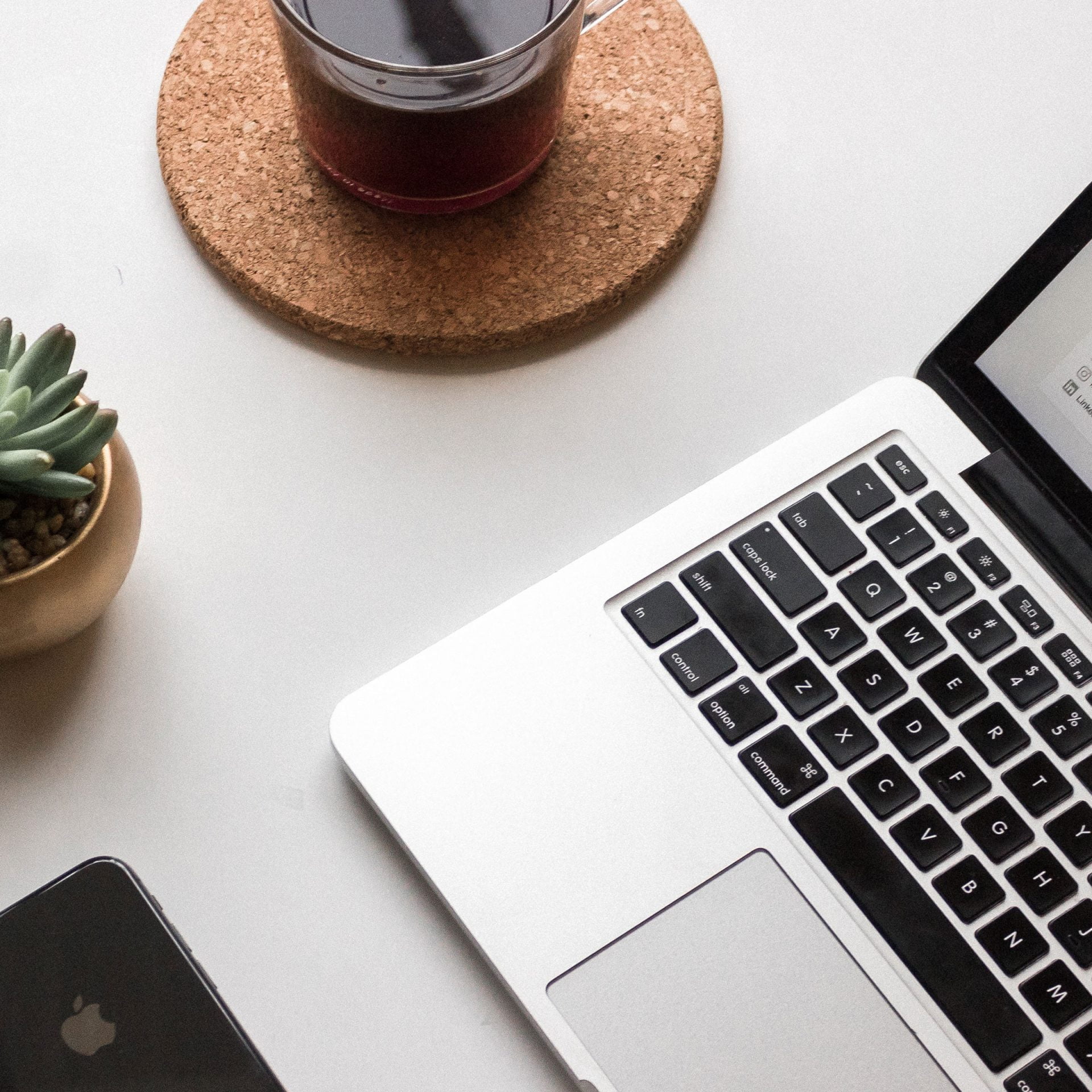 Basis cursus WordPress: laptop met kop koffie, vetplant en telefoon